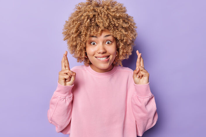 Cross fingers woman for Community Lottery