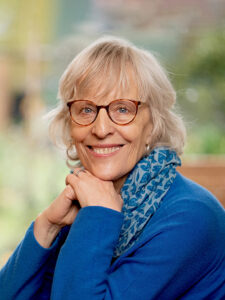 Photo of Vidyamala Burch wearing a blue top and blue and turquoise scarf