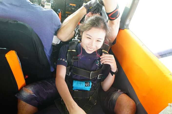 Photo of Stephanie sitting in the plane in front of the skydive instructor